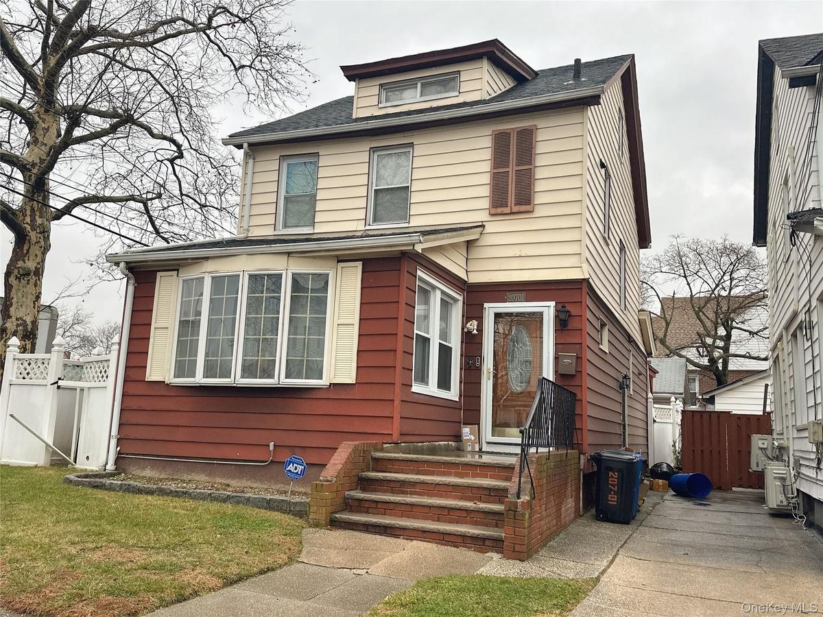 American foursquare style home with a gate