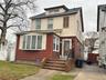 American foursquare style home with a gate