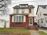 American foursquare style home with a shingled roof and a gate