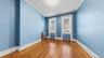 Spare room with ornamental molding, radiator heating unit, and wood-type flooring