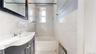 Full bathroom featuring tile walls, vanity, radiator, and shower / bathtub combination