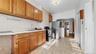 Kitchen with brown cabinetry, black gas range, light countertops, and arched walkways