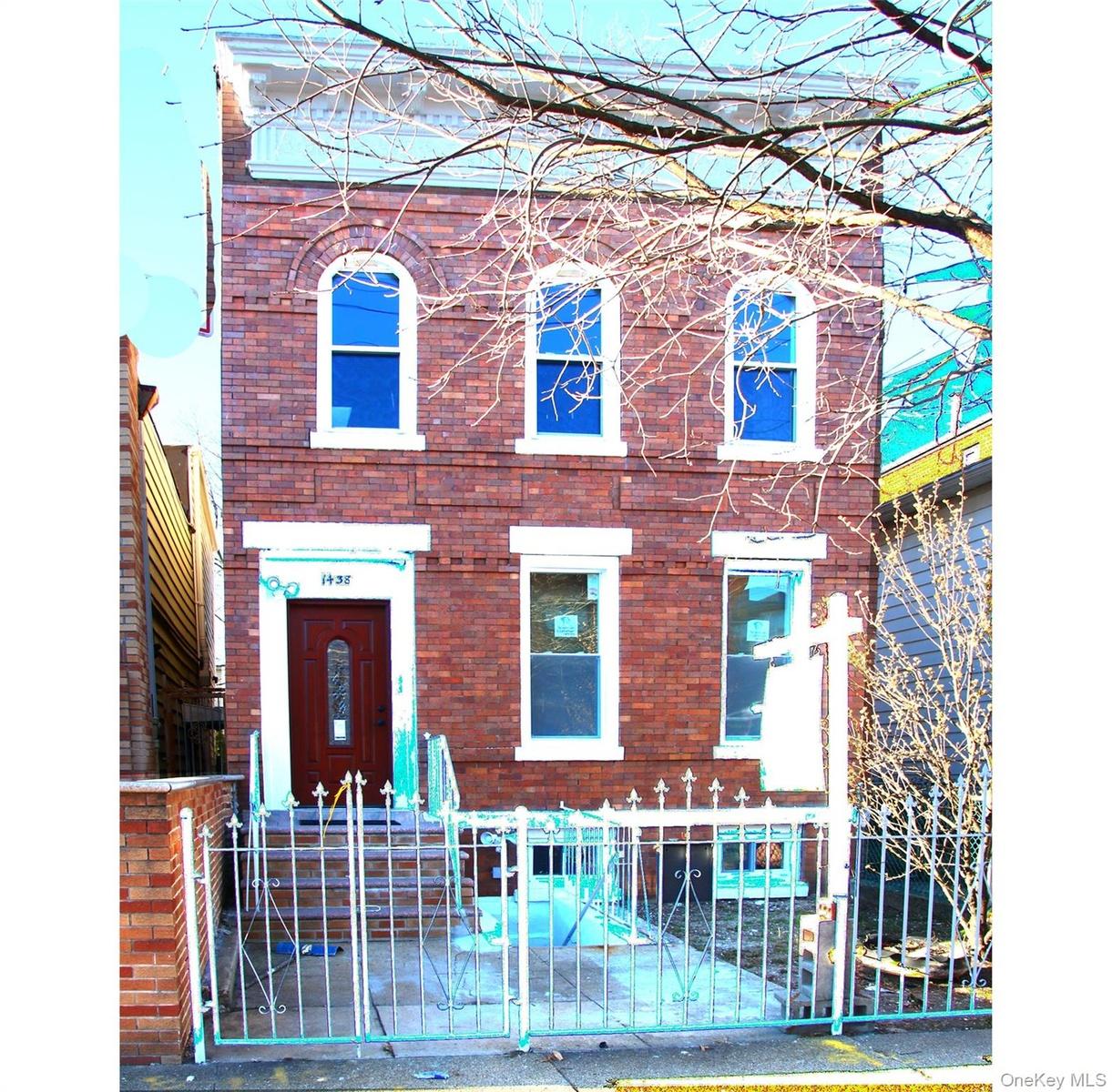 View of front of home with a fenced front yard and brick siding