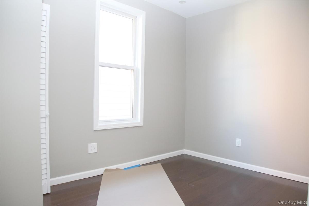 Spare room with dark wood-type flooring