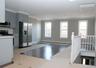 Kitchen with wood finished floors, stainless steel appliances, light countertops, gray cabinetry, and ornamental molding