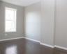 Empty room with baseboards and dark wood-style flooring
