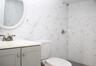 Full bath featuring a tile shower, tile walls, and vanity