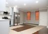 Kitchen with light countertops, stainless steel appliances, crown molding, dark wood finished floors, and baseboard heating
