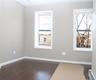 Empty room featuring a baseboard heating unit, dark wood-style floors, and healthy amount of natural light