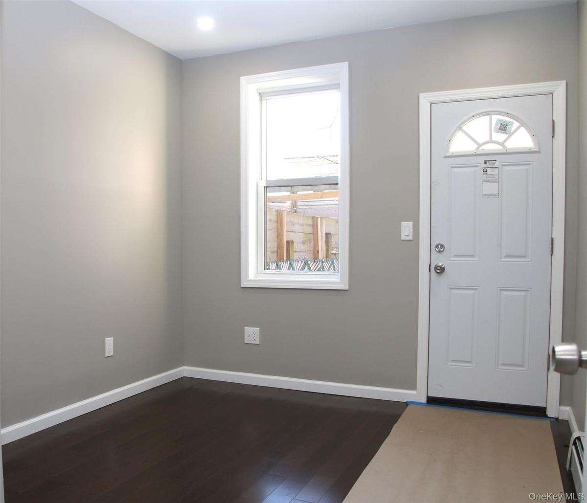 Foyer entrance featuring dark wood-style flooring, healthy amount of natural light, and baseboard heating