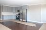 Kitchen featuring appliances with stainless steel finishes, ornamental molding, dark wood-style floors, gray cabinets, and tasteful backsplash