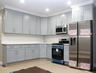 Kitchen with stainless steel appliances, crown molding, light stone countertops, and gray cabinets