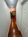 Hallway with dark wood-style flooring and baseboards