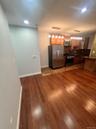 Kitchen featuring appliances with stainless steel finishes, hanging light fixtures, dark wood-type flooring, dark stone counters, and recessed lightin
