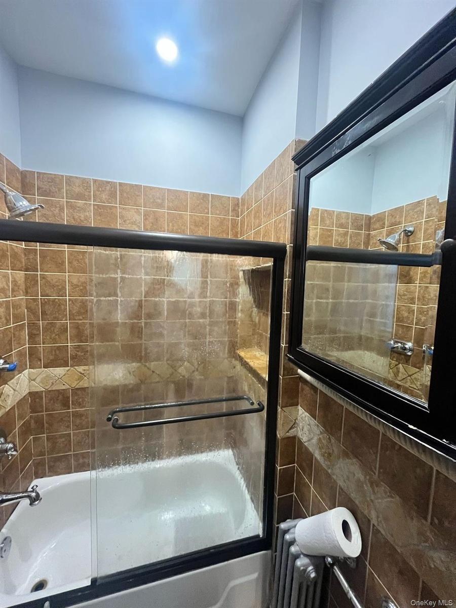 Bathroom with shower / bath combination with glass door