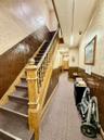 Stairs featuring a wainscoted wall, wallpapered walls, carpet, and wood walls