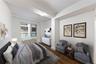 Bedroom with dark wood-style flooring and radiator