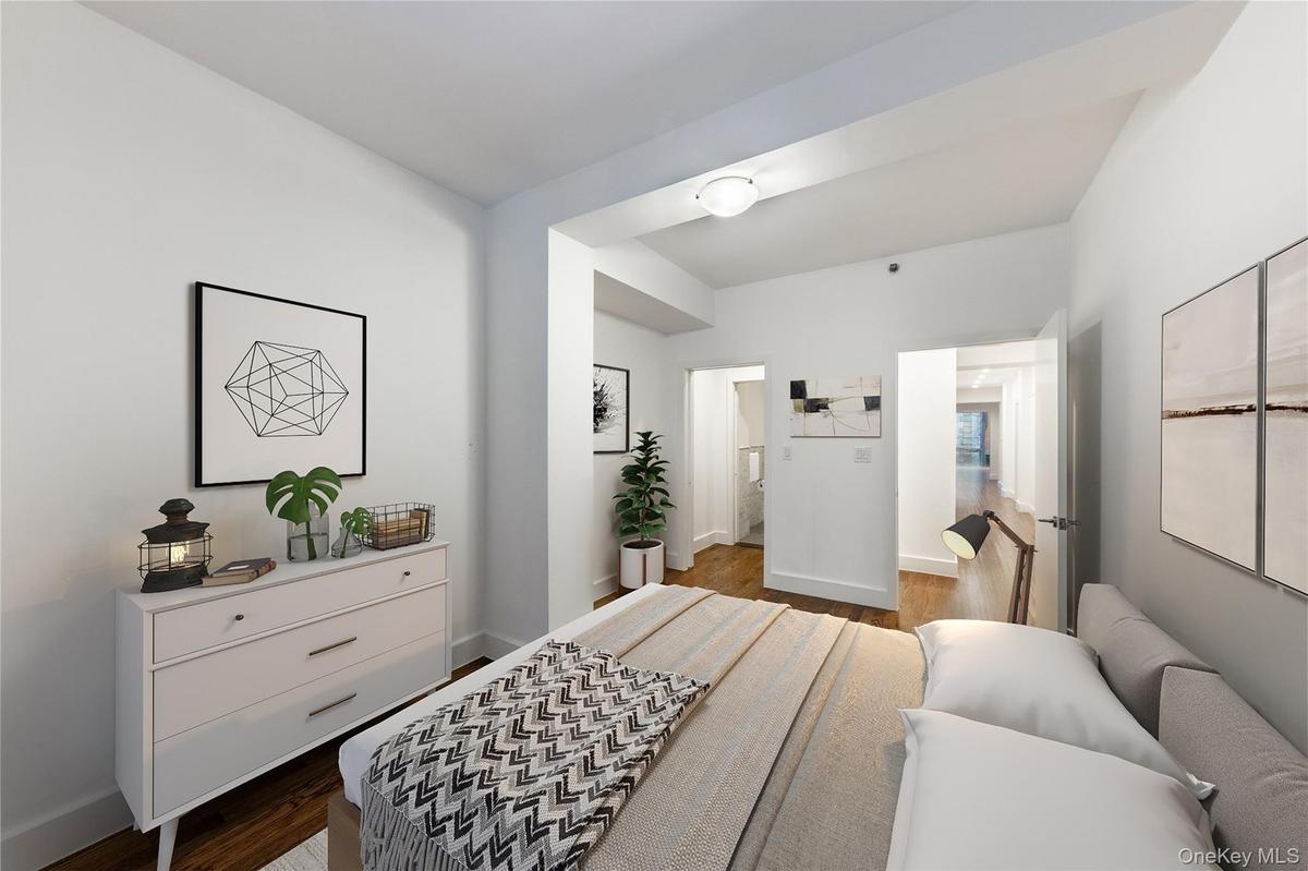 Bedroom featuring dark wood-style floors and baseboards