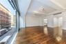 Unfurnished living room featuring beam ceiling and dark wood-style floors