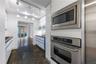 Kitchen featuring appliances with stainless steel finishes, white cabinets, and stone finish floors