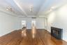 Unfurnished living room featuring beamed ceiling, a fireplace with flush hearth, dark wood-style floors, and track lighting
