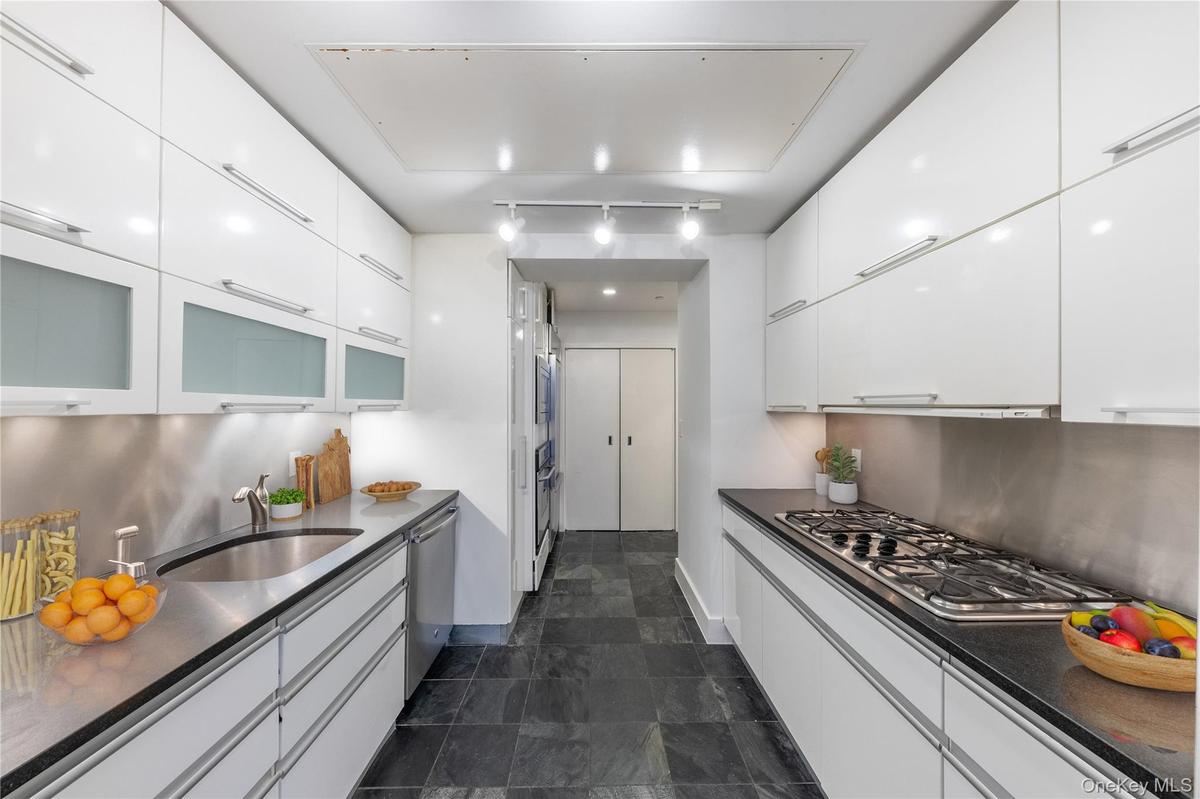 Kitchen with white cabinetry, modern cabinets, and glass insert cabinets