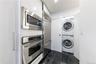 Laundry room featuring stacked washing machine and dryer