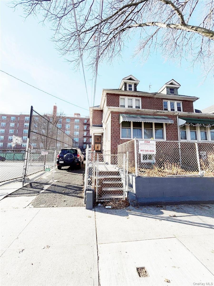 American foursquare style home with a gate, a fenced front yard, and brick siding