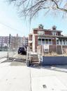 American foursquare style home with a gate, a fenced front yard, and brick siding