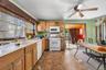 Kitchen featuring white appliances, ceiling fan, light countertops, and stone finish flooring