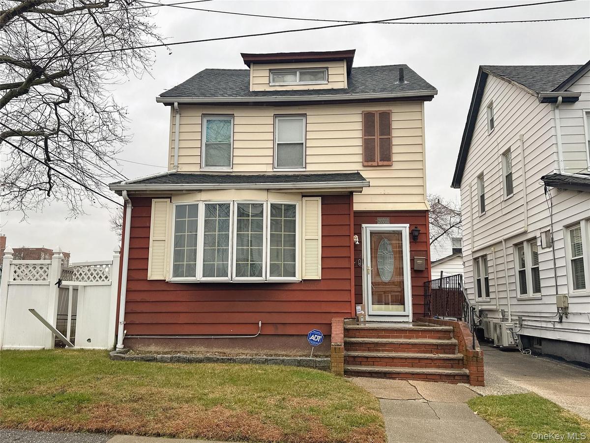 American foursquare style home with a shingled roof and a gate