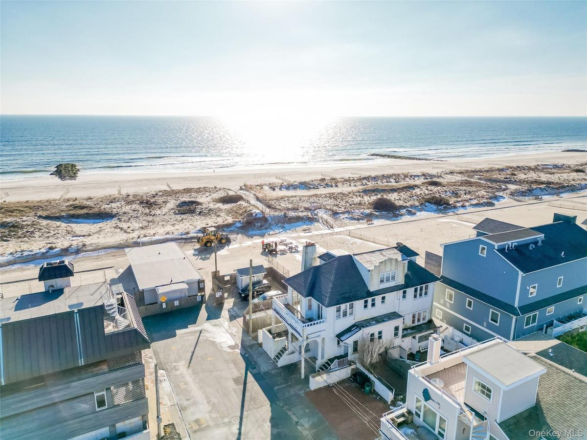 Aerial view of residential area featuring waterfront with a beach