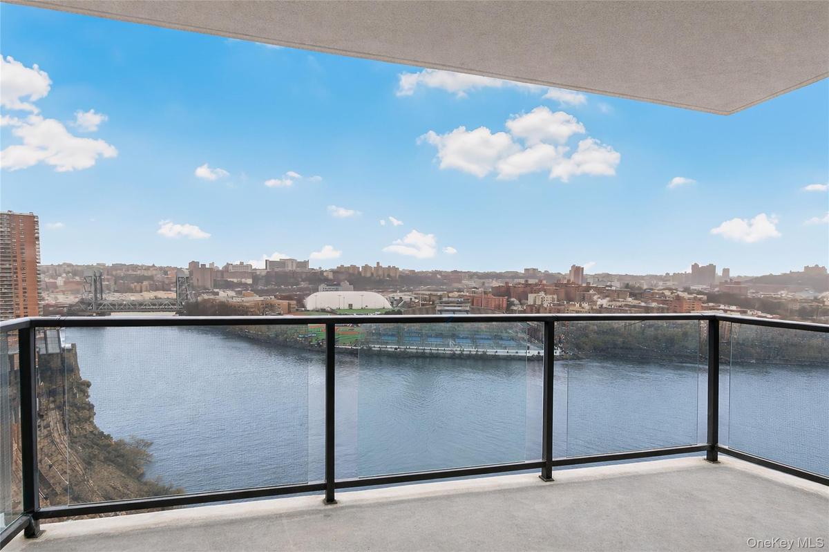 Balcony featuring a skyline view and a water view