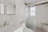 Full bathroom with vanity, a stall shower, and tile walls