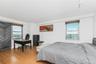 Bedroom featuring track lighting, wood finished floors, freestanding refrigerator, and a desk