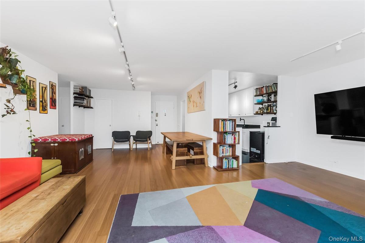 Living room with rail lighting and wood finished floors
