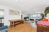 Living room with rail lighting and light wood-type flooring
