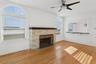 Unfurnished living room featuring a fireplace, light wood finished floors, and a ceiling fan