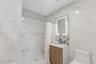 Bathroom featuring vanity, a marble finish shower, and stone wall
