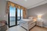 Bedroom with access to exterior, light wood-type flooring, and a water view