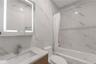 Full bathroom with vanity and a combined bath / shower with marble appearance