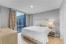 Bedroom with light wood-style floors, floor to ceiling windows, and recessed lighting