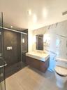 Full bath featuring a stall shower, vanity, light tile patterned flooring, tile walls, and recessed lighting