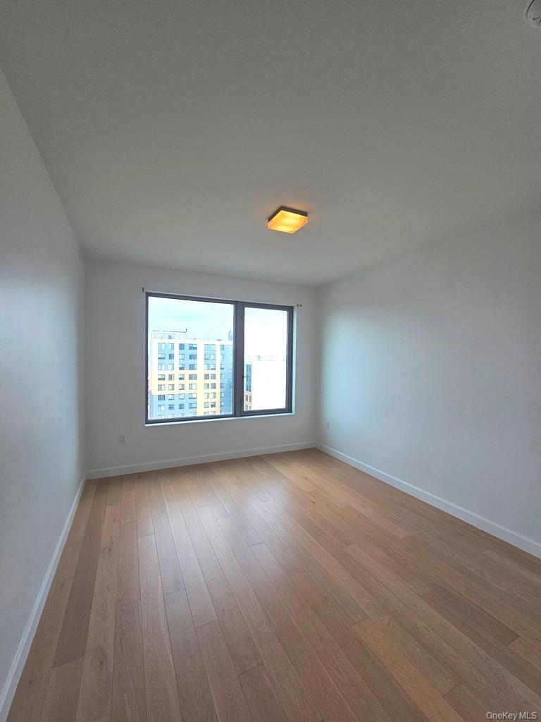 Empty room with baseboards and light wood finished floors