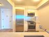 Kitchen featuring white cabinetry, appliances with stainless steel finishes, backsplash, light stone countertops, and modern cabinets