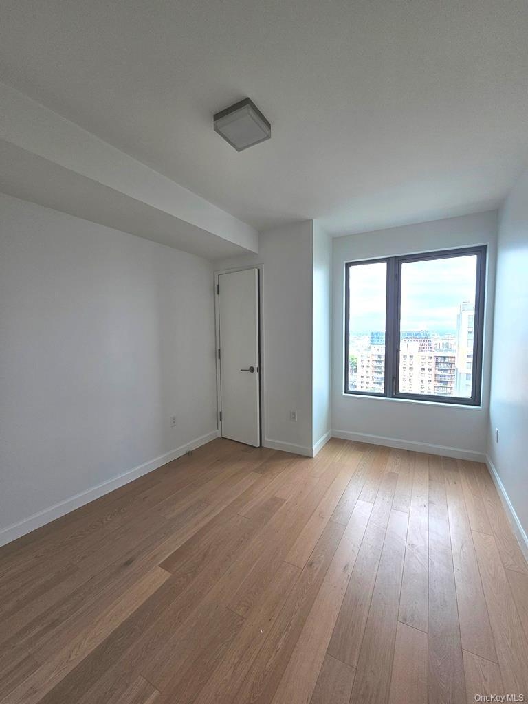 Unfurnished room with wood-type flooring and baseboards