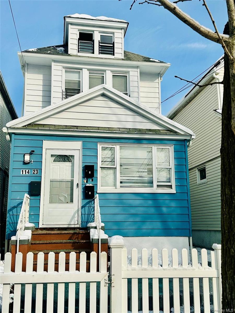 American foursquare style home with a fenced front yard and a gate