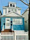 American foursquare style home with a fenced front yard and a gate