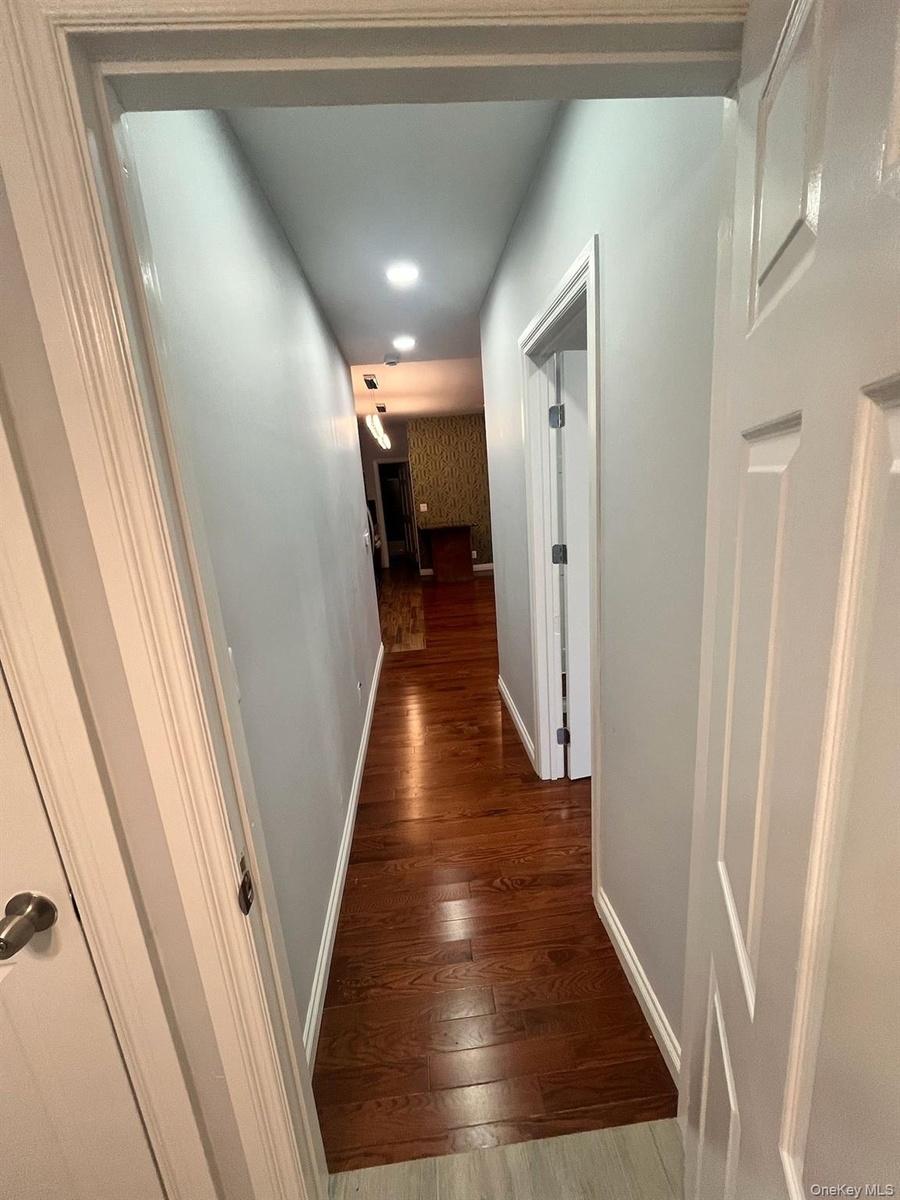 Hall featuring dark wood-type flooring and recessed lighting