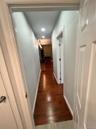 Hall featuring dark wood-type flooring and recessed lighting
